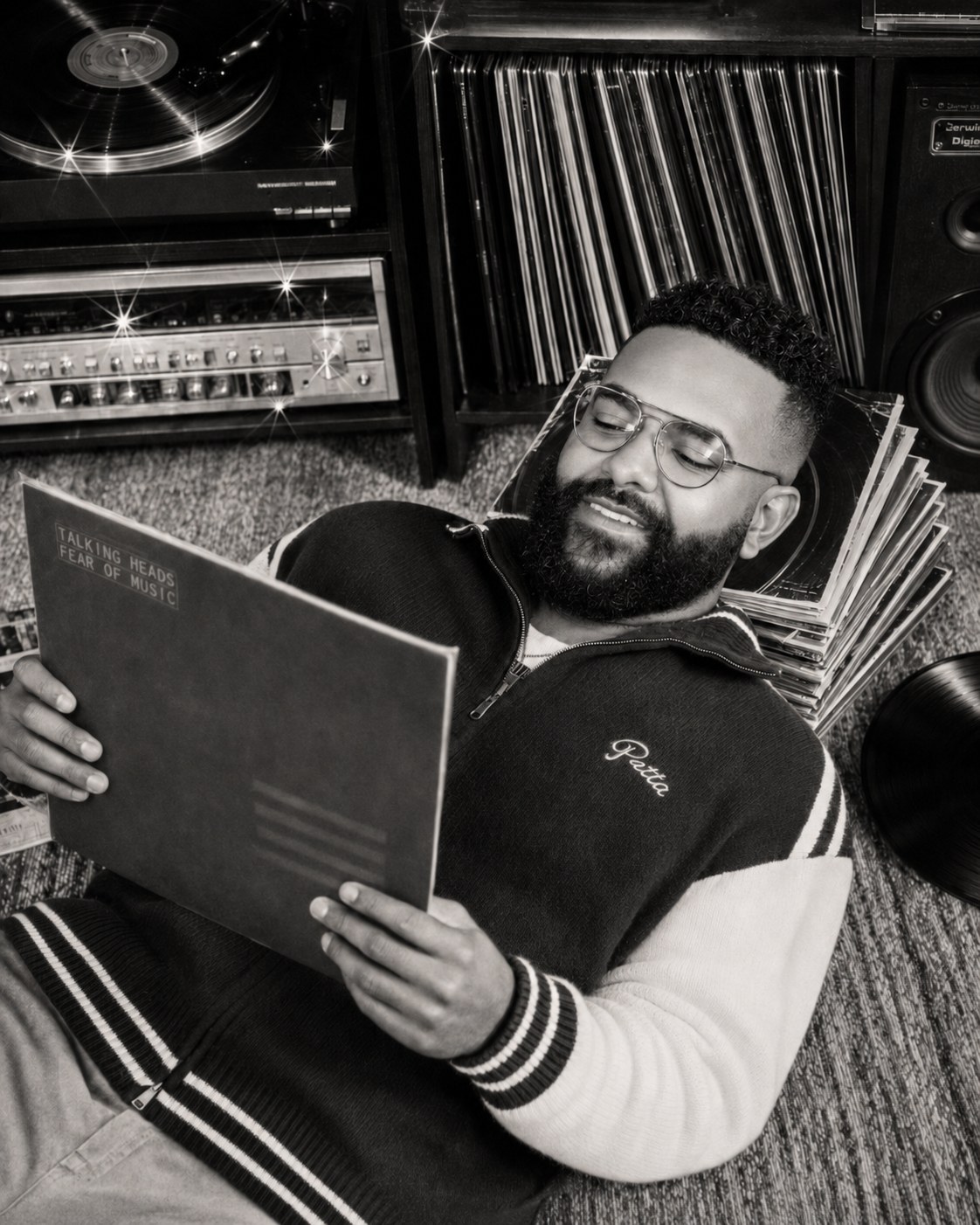 Yan Cohn reclining with a Talking Heads — Fear of Music vinyl record, surrounded by turntable, hi-fi gear and stacks of records